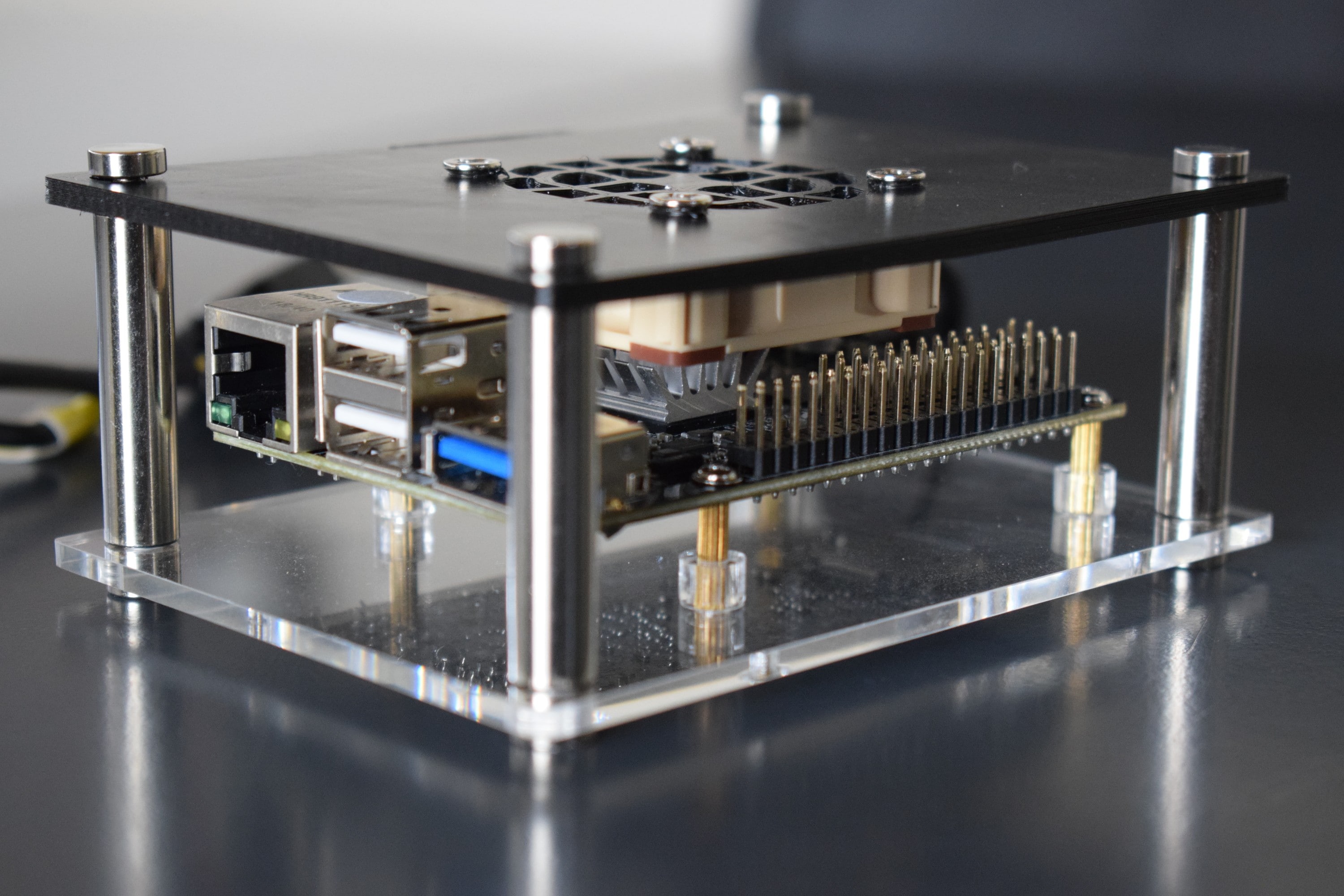 The assembled modified case with a Noctua NF-A4x10 5V PWM mounted to it. The SBC is mounted in the enclosure upside-down.